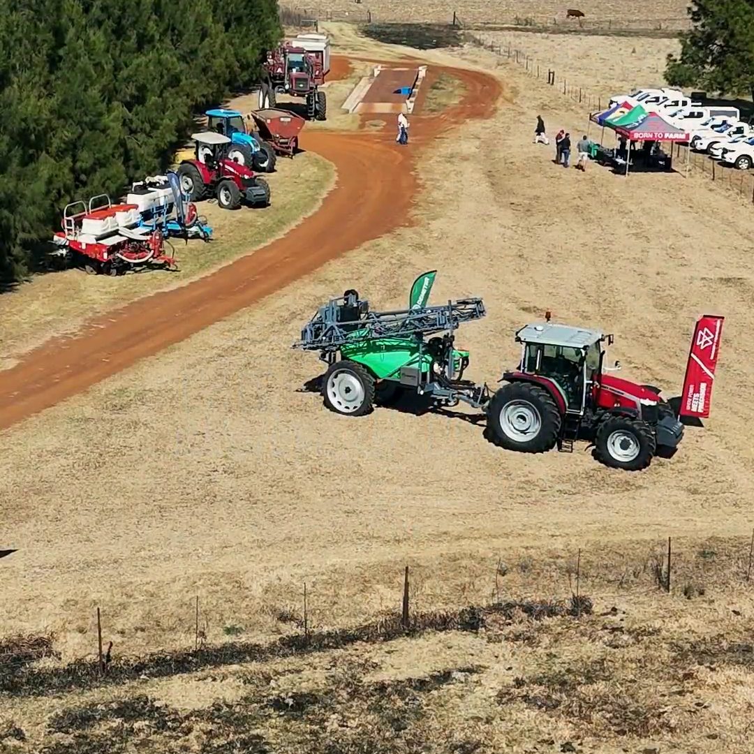 The Demeter sprayer behind a tractor on the demo field, from the air